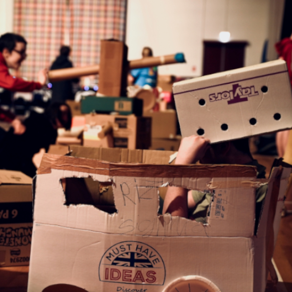 Children making play items out of large cardboard boxes
