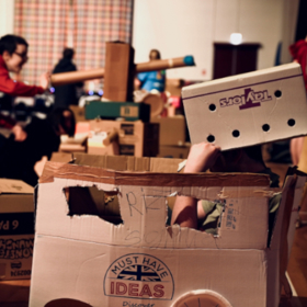 Children making play items out of large cardboard boxes