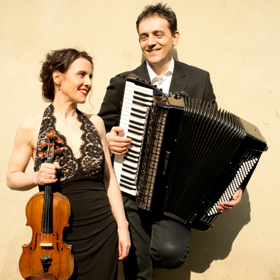 Andrea and Djordje Gajic holding a violin and accordion 